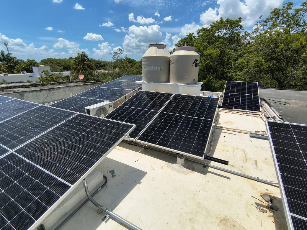 Paneles solares instalados sobre azotea bajo cielo despejado.